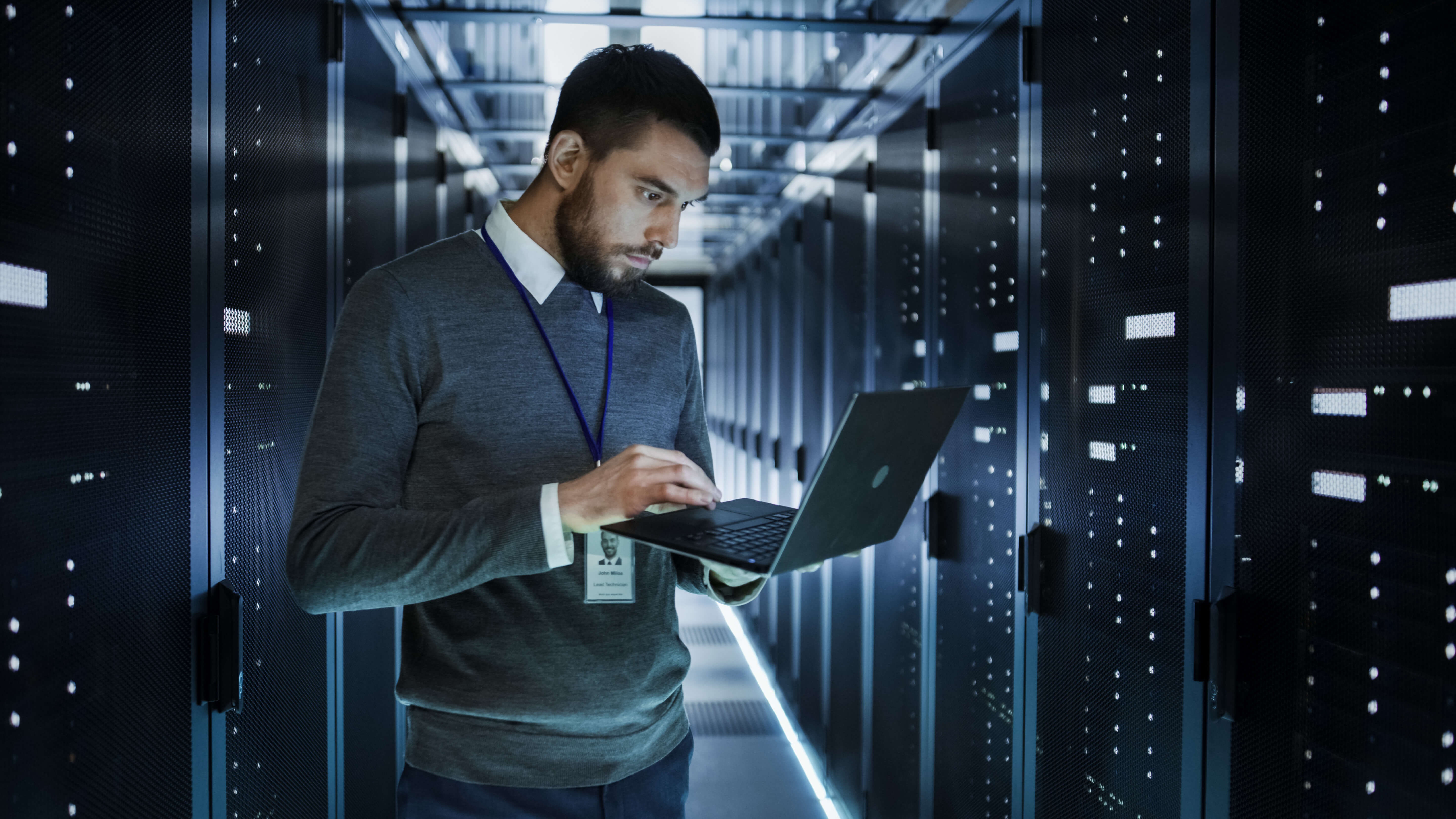 Techniker prüft mit dem Notebook den Zustand der Server im Rechenzentrum